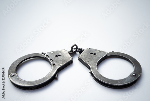 Metal police handcuffs on a white background. Arrest of suspects. Role-playing games with handcuffs.