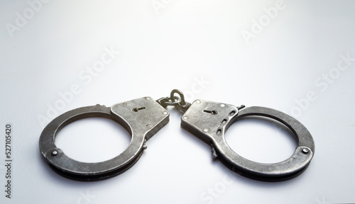 Metal police handcuffs on a white background.News of the arrest. Criminal chronicle. Deprivation of liberty.