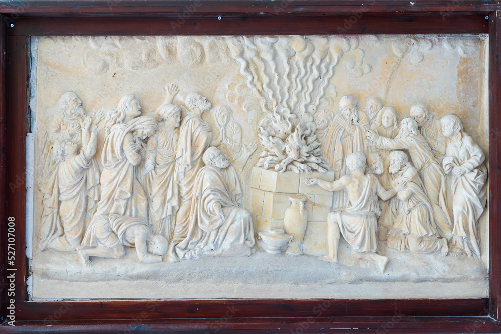 HAIFA, ISRAEL. June 26, 2022: Muhraka monastery of the Carmelite on the Carmel mount . Bas-relief depicting the priests of Baal at the altar and prophet Elijah