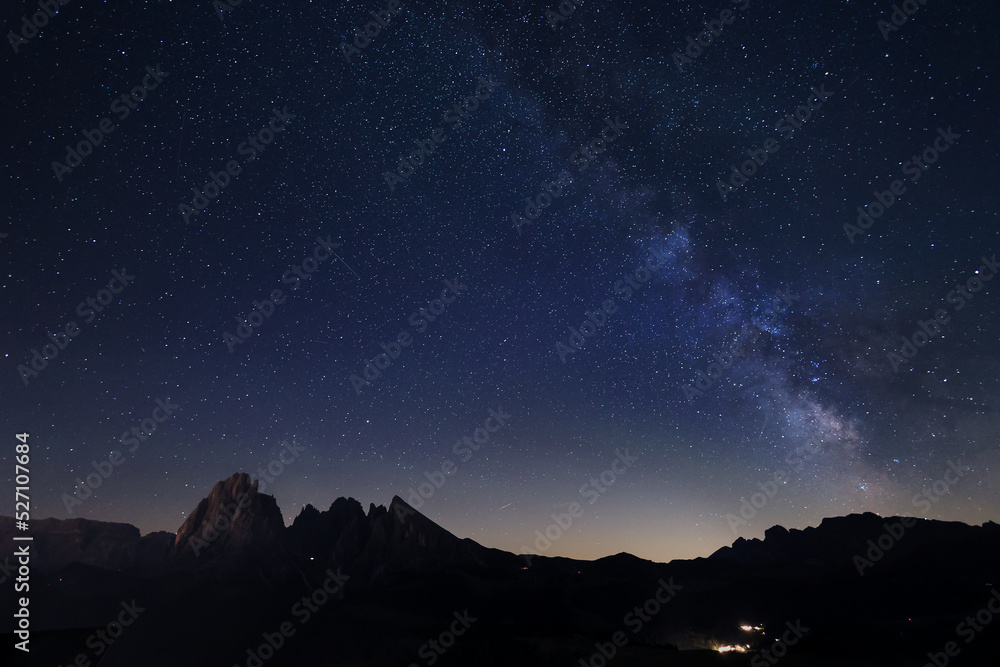 Milky Way over Alpe di Siusi or Seiser Alm) with Alps peaks Sassolongo and Sassopiatto on the left, Dolomites mountain, Sudtirol, Italy.