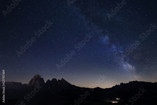 Milky Way over Alpe di Siusi or Seiser Alm  with Alps peaks Sassolongo and Sassopiatto on the left  Dolomites mountain  Sudtirol  Italy.