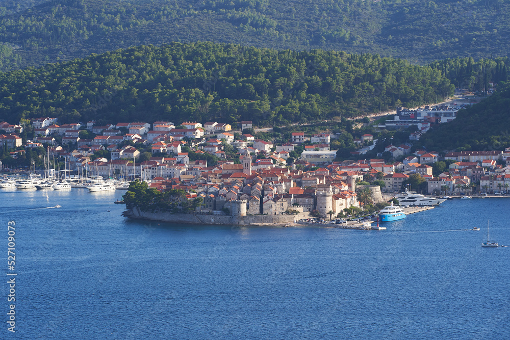 Panoramatic landscape picture of the old medieval scenic town Korcula in Croatia in south Dalmatia region in Europe. Picture is taken from mountain at Peljesac peninsula during hot summer evening.