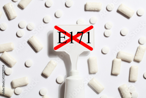 Titanium dioxide, E171, dangerous additive concept. gum, pills, toothpaste or cream and sign with E171 on white background. copy space photo