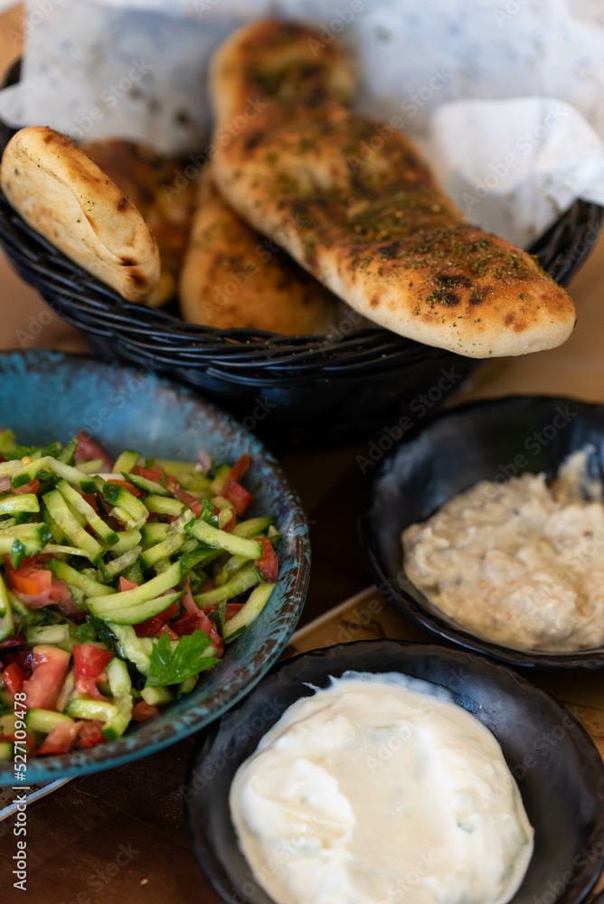 Israel and Lebanon cuisine served in restaurant. Middle eastern or Arabic Oriental restaurant. Several appetizer dishes and spreads for bread  and salad. 