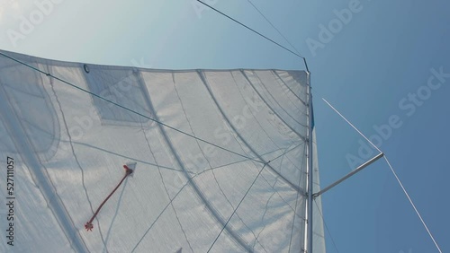 bottom view of the raised sail. a sail filled with wind. white sail of the yacht.
