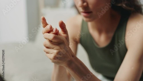 Woman in emotional distress rubbing her shaking hands sad and tired is highly agitated being at home close-up. Mental health problems and receiving bad news