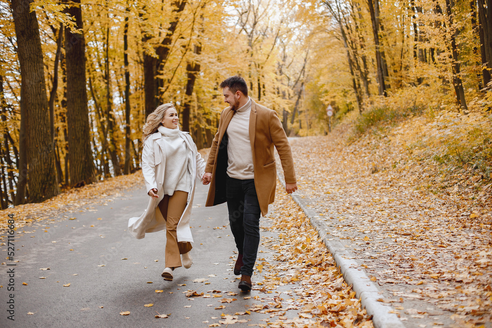 Fototapeta premium Romantic couple walking in autumn forest and holding hands