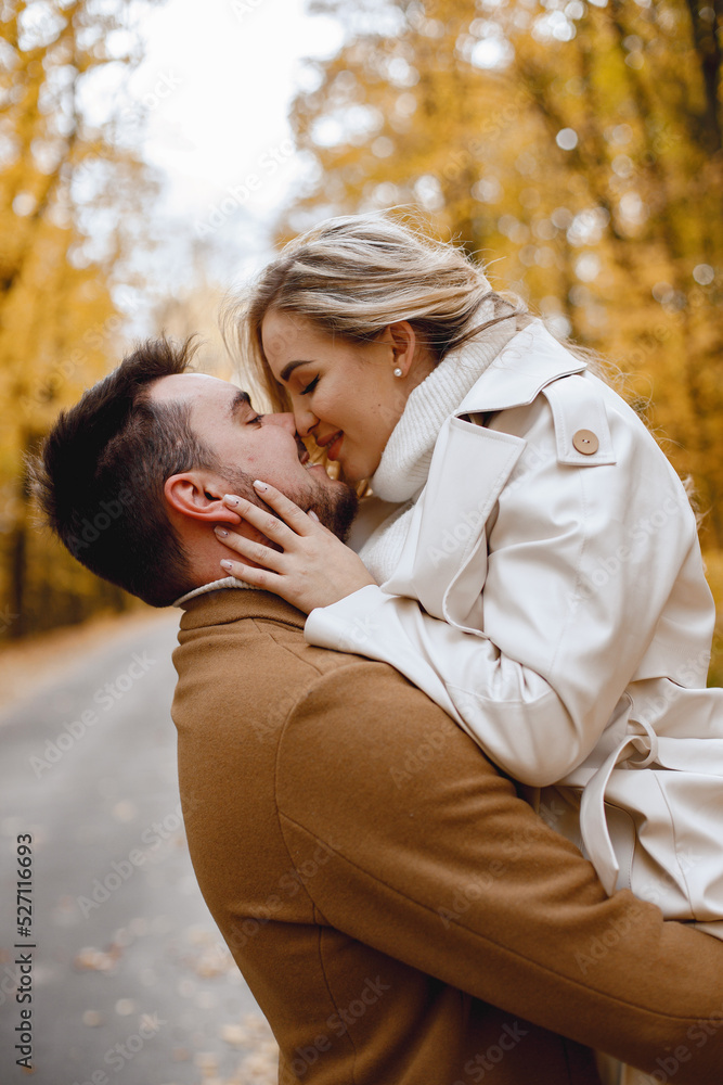 Fototapeta premium Romantic couple walking in autumn forest and kissing