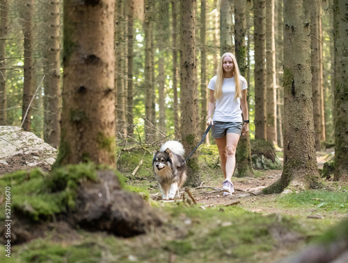 Woman and dog walking in forest