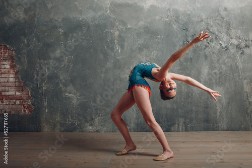 Fototapeta Naklejka Na Ścianę i Meble -  Young girl professional gymnast woman dance rhythmic gymnastics at studio.