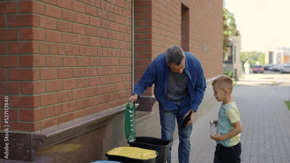Dad teaches his son to properly sort glass garbage. Father and son sorting the glass bottles properly. Recycling. Ecology and enviromental problems concept Dad teaches his son to properly sort glass garbage. Father and son sorting the glass bottles properly. Recycling. Ecology and enviromental problems concept