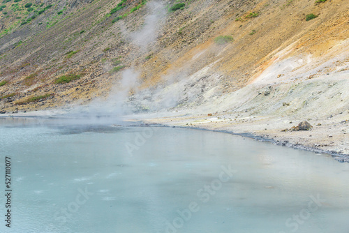 hot mineralized lake with thermal spring and smoking fumaroles in the caldera of the Golovnin volcano on the island of Kunashir