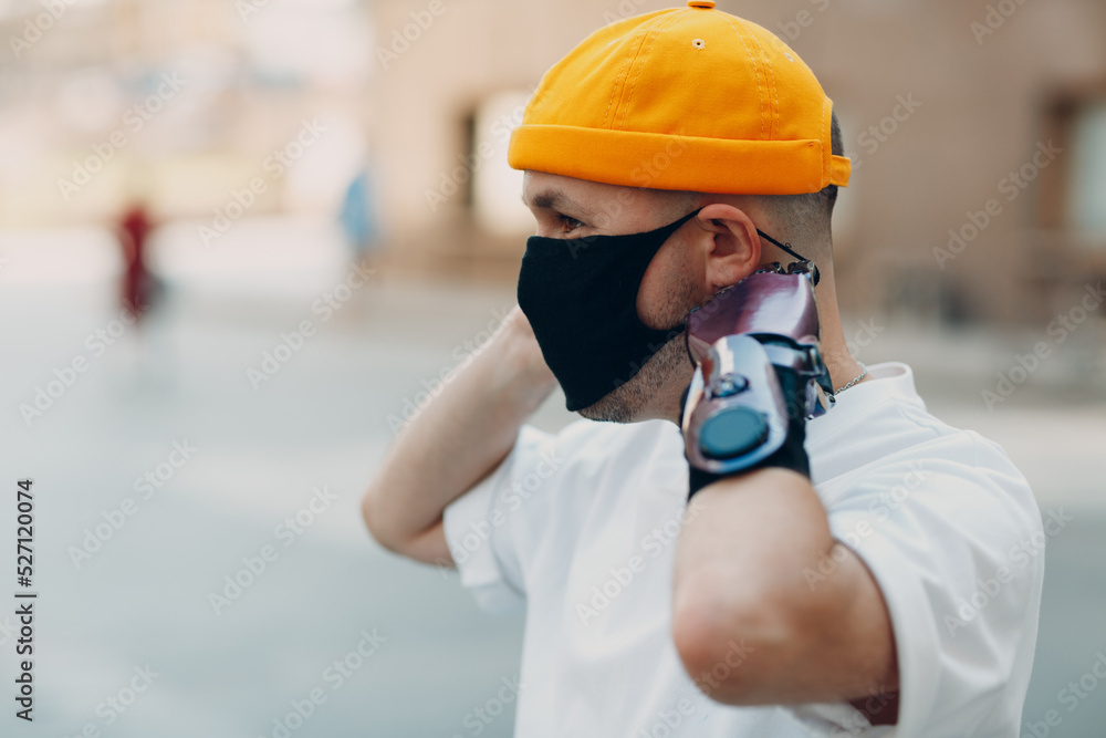 Young disabled man put on medical protective face mask with artificial prosthetic hand Young disabled man put on medical protective face mask with artificial prosthetic hand