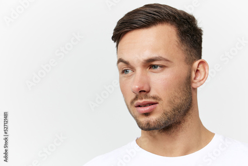 Closeup portrait. Flirted tanned handsome man in basic t-shirt raises eyebrow look aside posing isolated on white studio background. Copy space Banner Mockup. People emotions Lifestyle concept