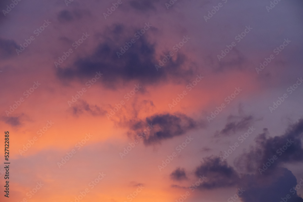Fototapeta premium Dark clouds against a scarlet pink sky during sunset.
