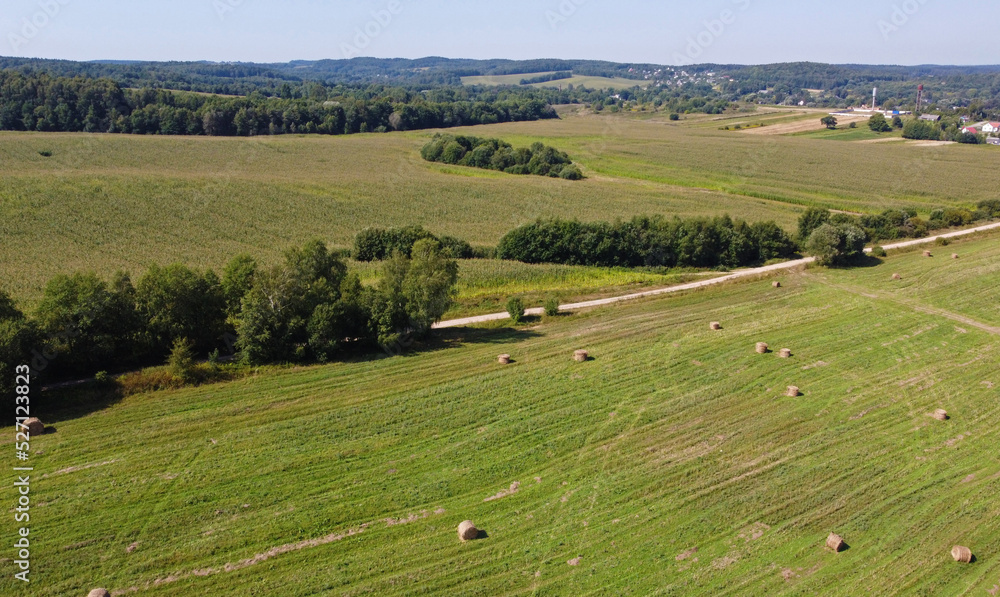 Aerial view of agro fields with harvesting and haystacks