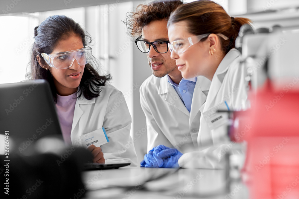 science research, work and people concept - international team of scientists with laptop computer working in laboratory science research, work and people concept - international team of scientists with laptop computer working in laboratory