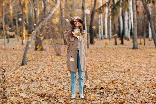 Young woman model in autumn park with yellow foliage maple leaves. Fall season fashion © primipil