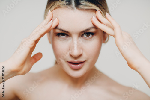 Young adult woman doing facial gymnastics self massage and rejuvenating exercises face building and lifting