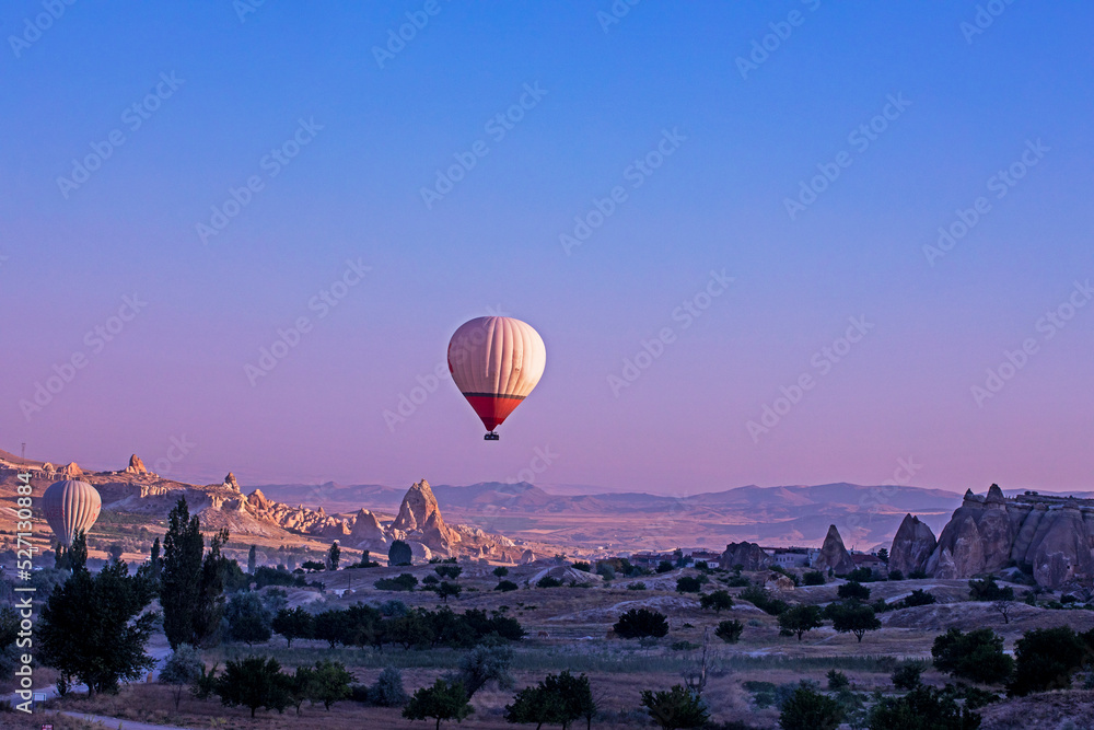 balloon over the hills in the mountains illuminated by the rays of the sun at dawn in the vicinity of Cappadocia View from above