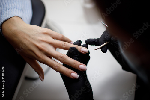 Manicure process female hands finger nails polish. © primipil