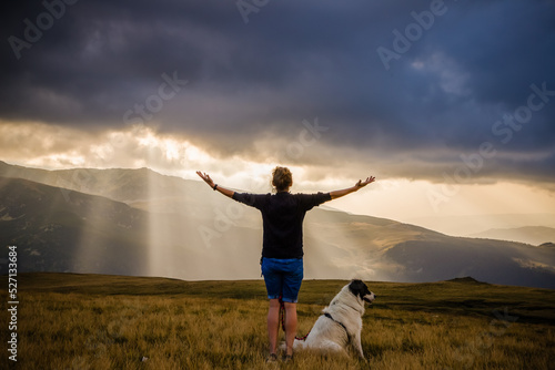 woman and dog watching amazing panorama of heavenly lights at sunset in high mountains © Melinda Nagy