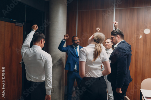 Businessman and businesswoman team doing warming up exercises before office meeting. Business healthy successful people group man and woman after conference discussion with boss.