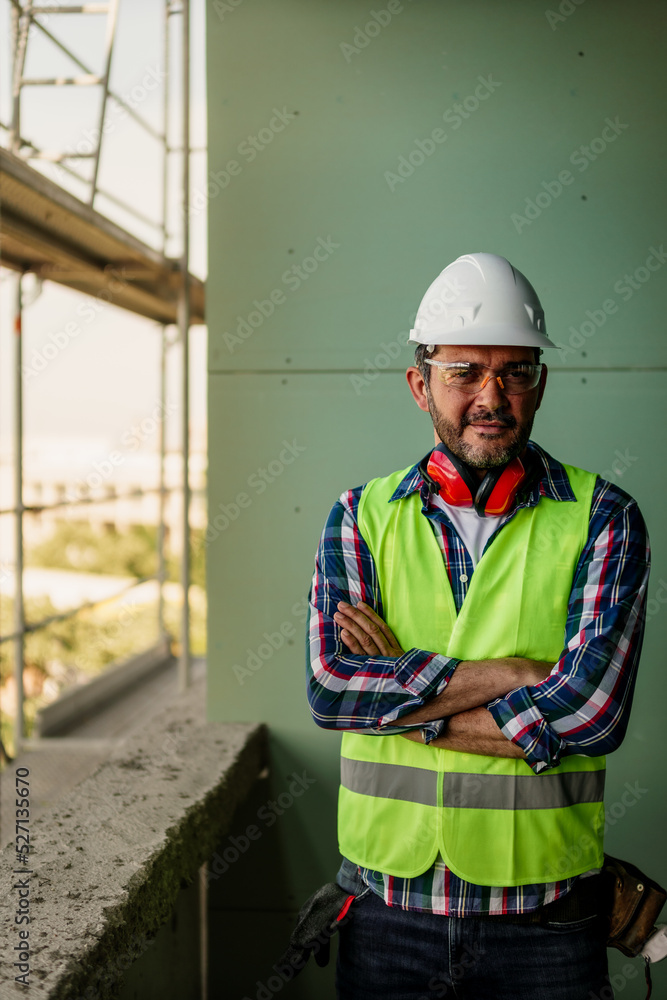 Portrait of men in 40s, construction worker. He is standing in construction and posing for camera. Portrait of men in 40s, construction worker. He is standing in construction and posing for camera.