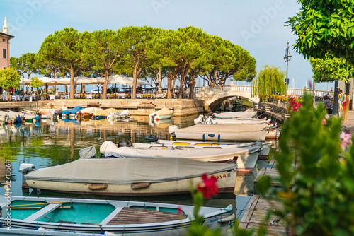 Medium shot of Desenzano s dock with lots of colorful boats in a sunny day. Desenzano  Brescia  on the Garda Lake.