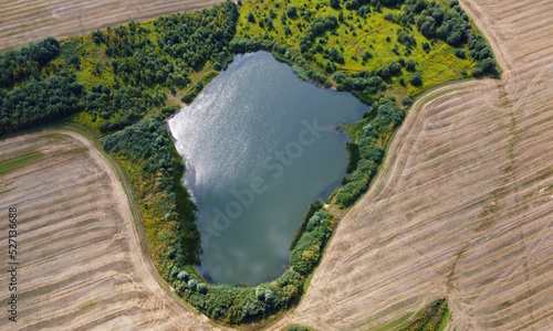 Aerial view of the lake in agro fields. Rustic landscape