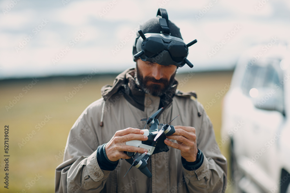 Man controlling fpv quadcopter drone for aerial photography and videography with goggles antenna remote controller. Man controlling fpv quadcopter drone for aerial photography and videography with goggles antenna remote controller.