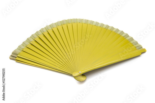 Mustard colored fan, isolated on white background. A fan is a fashion accessory designed so that with a rhythmic and variable movement of the wrist, air can be moved and cooling facilitated.