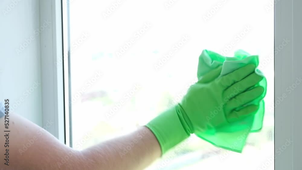 A man washes a glass window and a plastic frame with a folk remedy with household soap. Ecology. A man washes a glass window and a plastic frame with a folk remedy with household soap. Ecology.