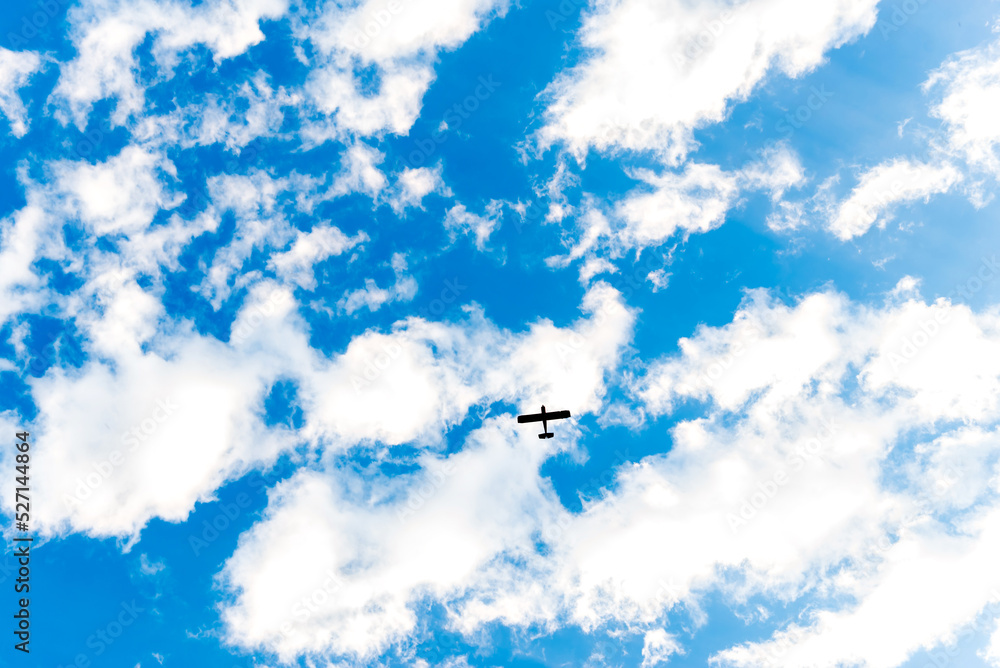 Blue sky with the silhouette of a plane flying through the clouds. Blue sky with the silhouette of a plane flying through the clouds.