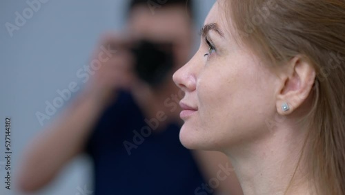 Wallpaper Mural Close-up side view of Caucasian woman smiling as blurred Middle Eastern man taking photo on camera at background. Confident patient posing for before-after photo with plastic surgeon photographing Torontodigital.ca