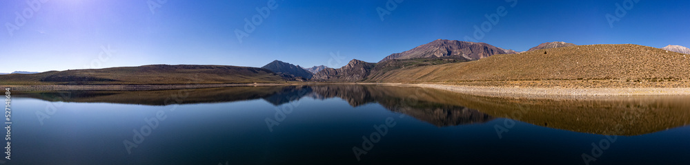 Panorama at grant lake with mountains reflecting on water on a clear summer day 