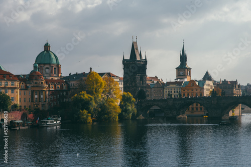 view of the Charles Bridge and the architecture of the old town of Prague, Czech Republic. Boats on the river. Beautiful old town in autumn