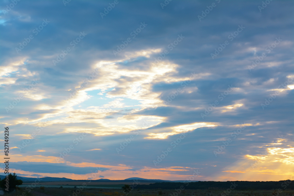 Picturesque view of beautiful countryside and cloudy sky at sunset