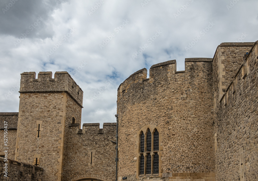 London, England, UK - July 6, 2022: Tower of London. Closeup of brown stone rampart section on south side against gray cloudscape.