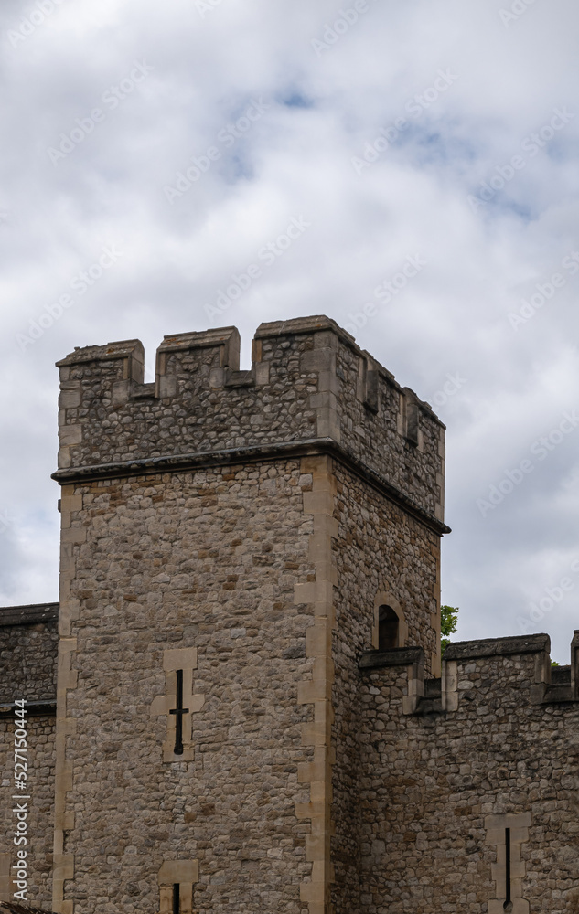London, England, UK - July 6, 2022: Tower of London. Closeup of brown stone lookout tower part of ramparts under white cloudscape.