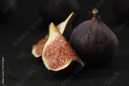 Tasty raw figs on black slate table, closeup