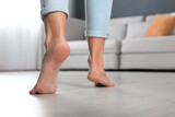 Woman walking barefoot at home, closeup. Floor heating concept