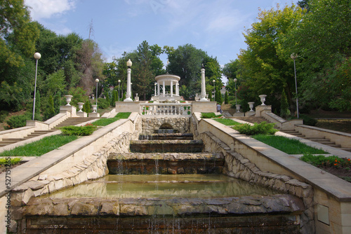 Moldova, Kishinev. 24.08.2022. View of a white gazebo with columns, fountains and water flowing 