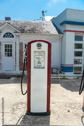 Vintage red gasoline pumps outside of an old gas station .