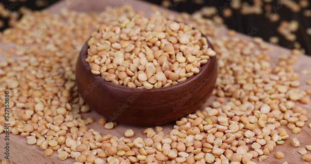Throw pea groats on the table in the kitchen, cooking dishes from traditional crushed yellow peas Throw pea groats on the table in the kitchen, cooking dishes from traditional crushed yellow peas