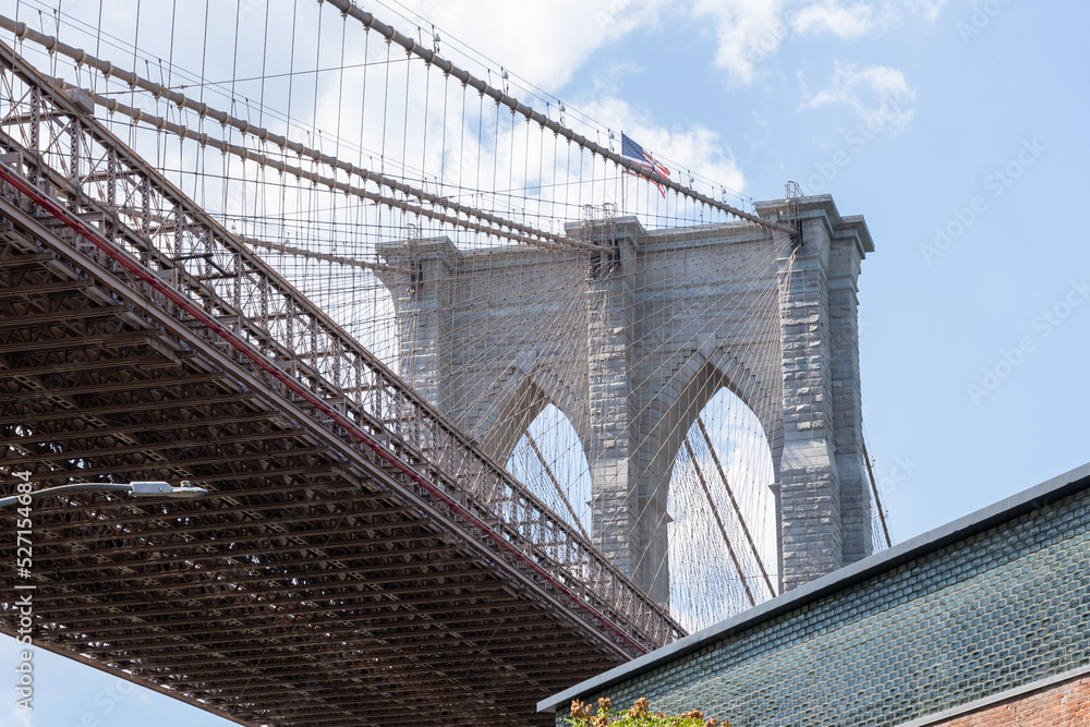 Obraz premium Brooklyn Bridge is shown in New York City, NY, USA. The Brooklyn Bridge is a hybrid cable-stayed-suspension bridge in New York City spanning the East River. 