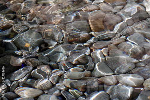 A bed of rocks and pebbles under clear creek water