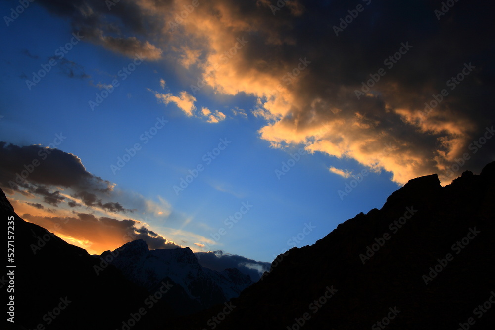 Dramatic sunset and golden sunrays emanating from behind the peaks around Boroghil valley national park in Pakistan. 