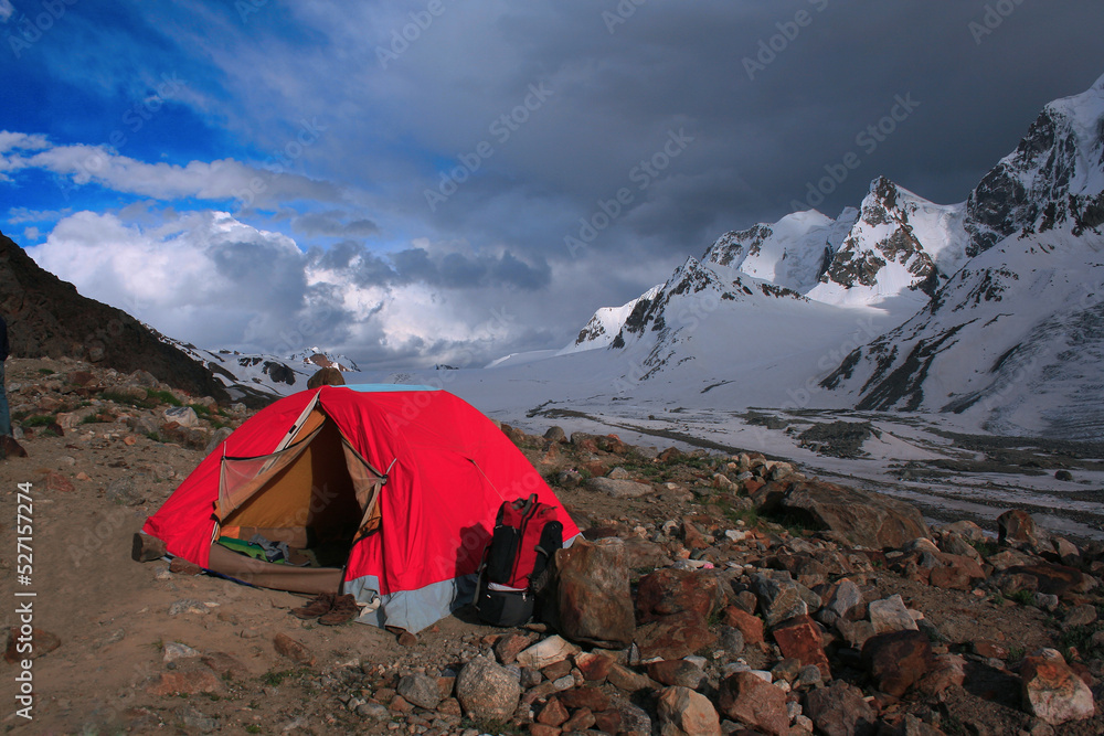 A tent at the base camp of Darkoot pass, near Lake Karambar in Pakistan. Captured around sunset and in a cloudy weather with beautiful sky. 