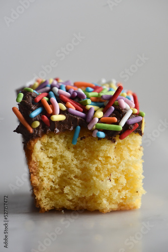 Square Piece of Vanilla Cake With Chocolate Buttercream And Rainbow Jimmies photo